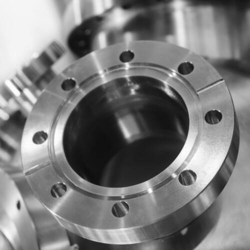 Industrial background, heavy metal housing with welded metal flanges. Shallow depth of field.